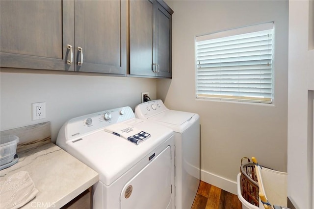 laundry room with dark wood-type flooring, cabinets, and washer and clothes dryer