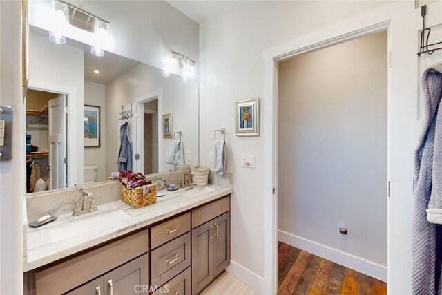 bathroom with vanity, wood-type flooring, and toilet