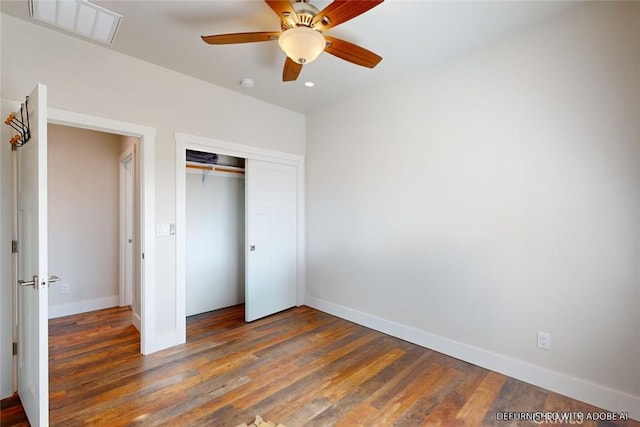 unfurnished bedroom with ceiling fan, dark hardwood / wood-style floors, and a closet