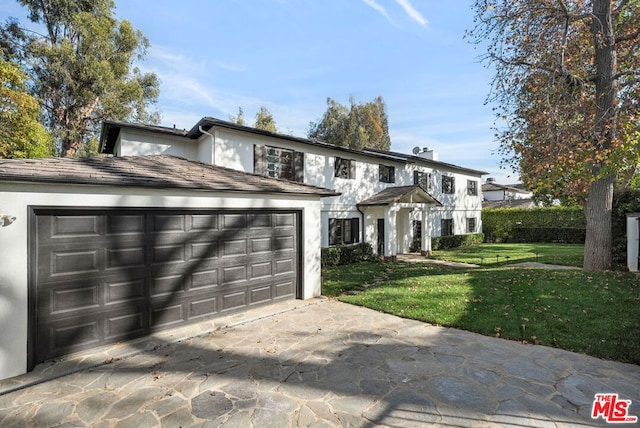 view of front facade with a front yard and a garage