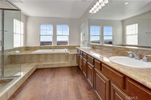 bathroom featuring vanity, hardwood / wood-style floors, separate shower and tub, and a water view