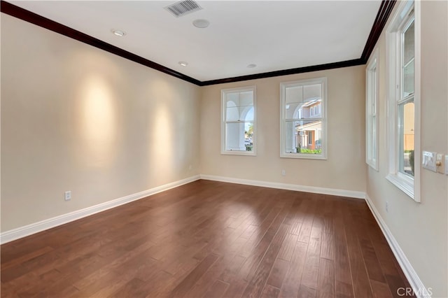 empty room featuring dark hardwood / wood-style flooring and ornamental molding