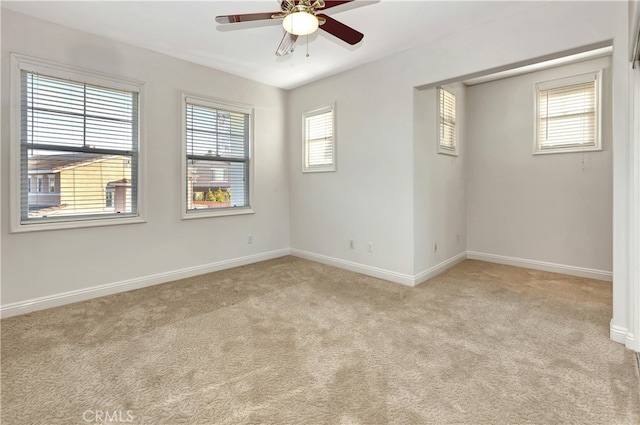 carpeted spare room featuring ceiling fan