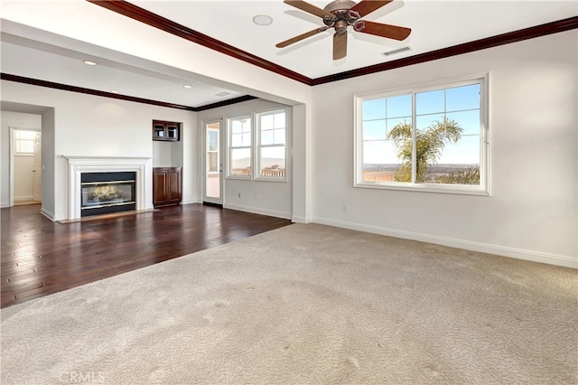 unfurnished living room featuring ceiling fan, crown molding, and dark hardwood / wood-style floors