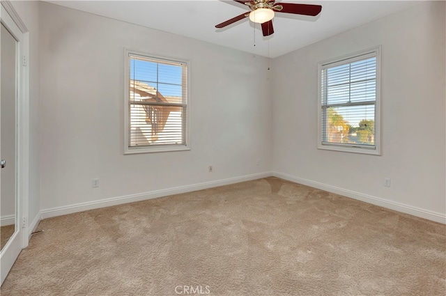 carpeted spare room with ceiling fan