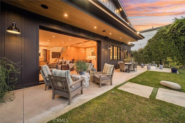 patio terrace at dusk with a yard and an outdoor hangout area