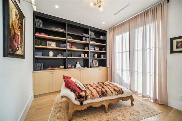 sitting room with built in features and light hardwood / wood-style floors