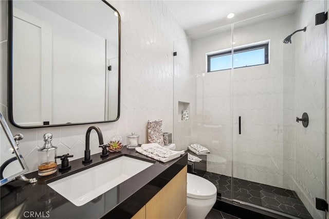 bathroom with vanity, toilet, a shower with door, and decorative backsplash