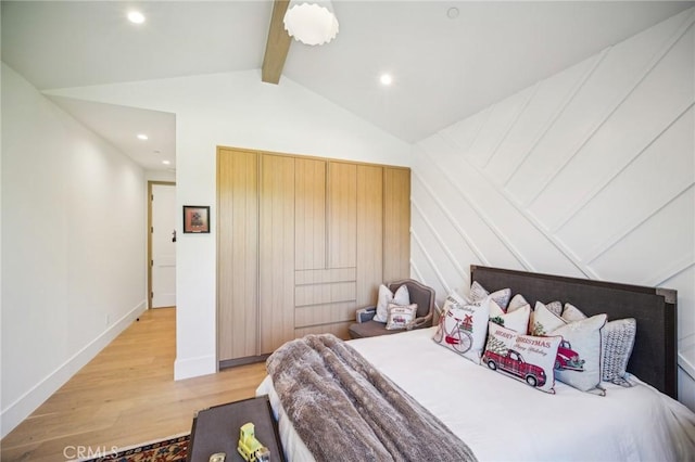 bedroom featuring lofted ceiling with beams and light hardwood / wood-style flooring