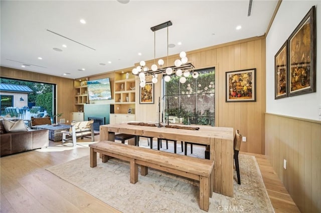 dining area featuring built in shelves, a wealth of natural light, and wood walls