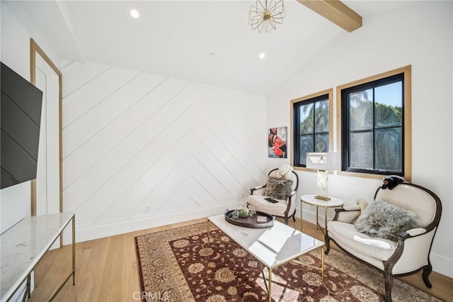 living area featuring hardwood / wood-style flooring and vaulted ceiling with beams