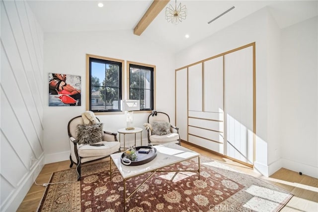 sitting room with hardwood / wood-style floors and vaulted ceiling with beams