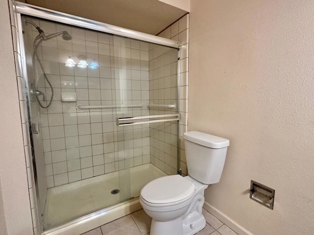 bathroom featuring tile patterned flooring, an enclosed shower, and toilet