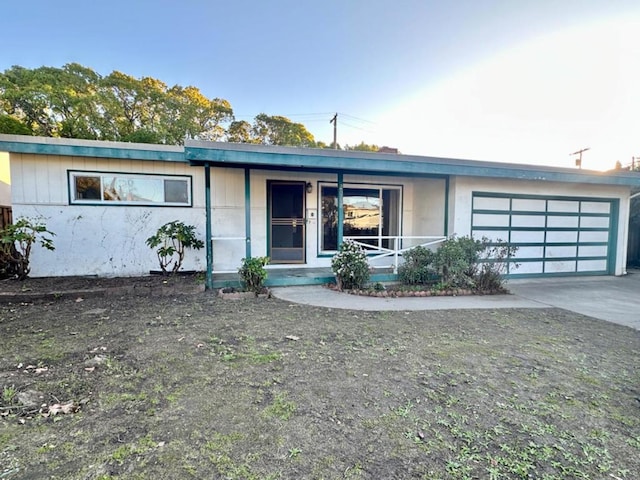 ranch-style house featuring a garage and covered porch