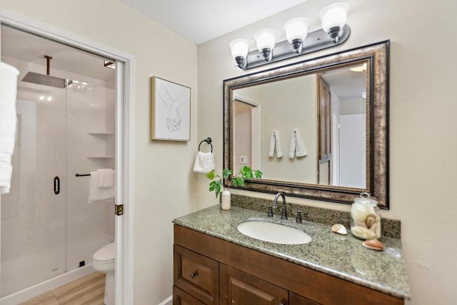 bathroom with toilet, walk in shower, wood-type flooring, and vanity