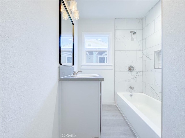 bathroom with tiled shower / bath combo and vanity