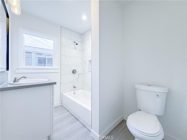 full bathroom featuring toilet, vanity, and tiled shower / bath