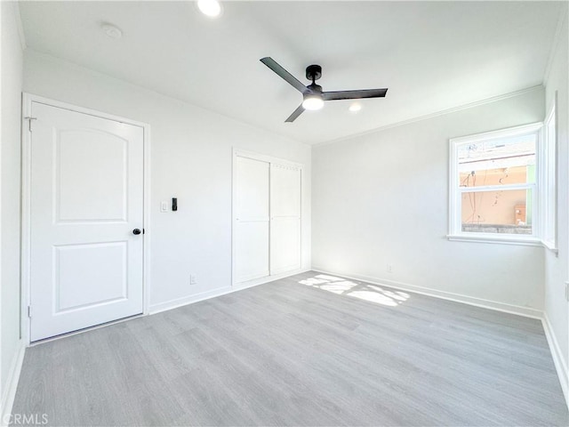 unfurnished bedroom with light wood-type flooring, ceiling fan, and a closet