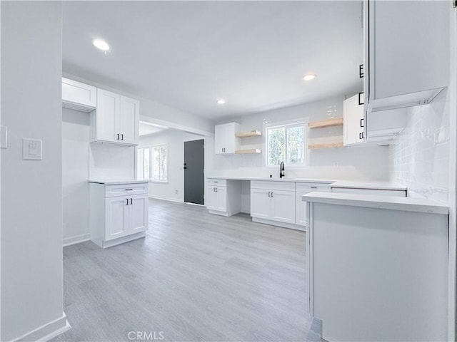 kitchen with plenty of natural light, white cabinets, and decorative backsplash