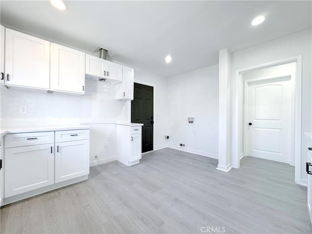 clothes washing area with cabinets, light wood-type flooring, washer hookup, electric dryer hookup, and gas dryer hookup