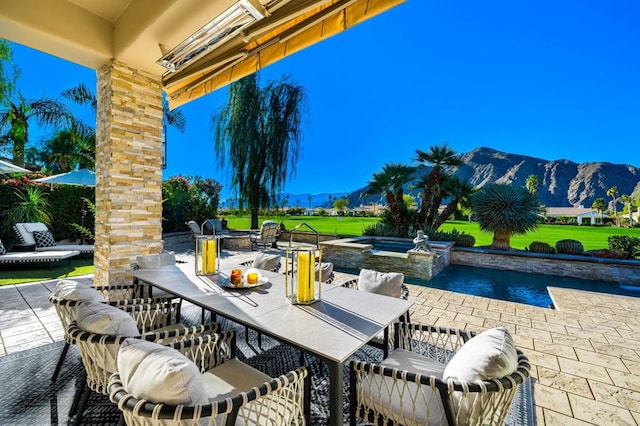 view of patio / terrace featuring a pool with hot tub and a mountain view