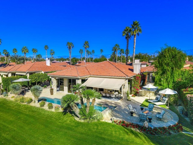 rear view of property featuring a yard, exterior bar, and a patio