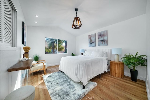 bedroom with lofted ceiling and light hardwood / wood-style floors