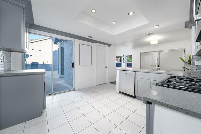 kitchen with sink, a tray ceiling, dishwasher, and gray cabinetry