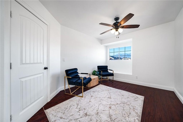 living area with dark wood-type flooring and ceiling fan