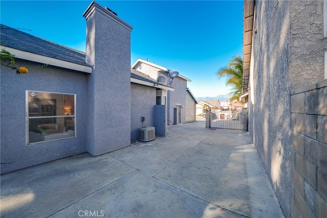 view of side of home with a patio and central AC unit