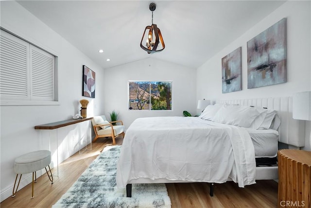 bedroom with light wood-type flooring and vaulted ceiling