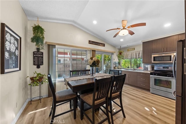 dining space featuring light hardwood / wood-style floors, ceiling fan, and lofted ceiling