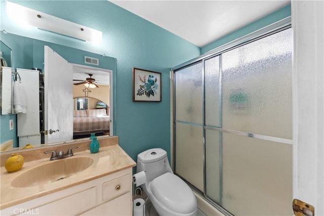 bathroom featuring ceiling fan, an enclosed shower, vanity, and toilet