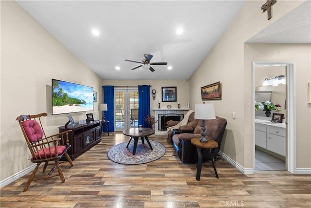 living room with lofted ceiling, french doors, hardwood / wood-style floors, and ceiling fan