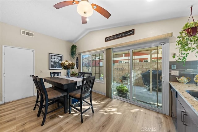 dining space featuring vaulted ceiling and light hardwood / wood-style floors