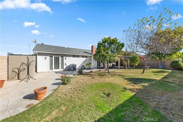 rear view of house with french doors, a patio, central AC, and a lawn