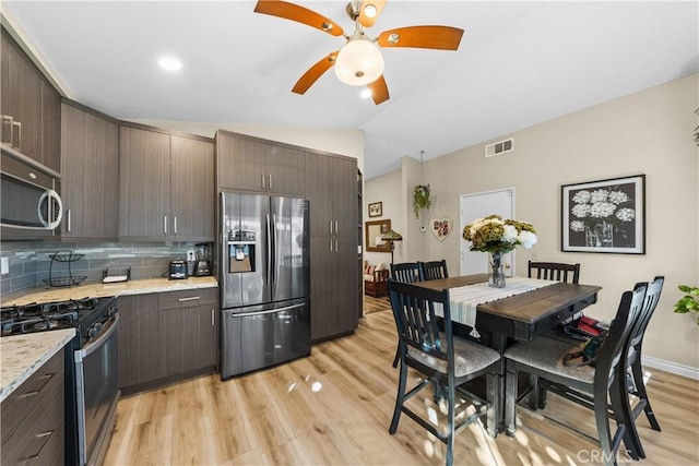 kitchen featuring stainless steel appliances, light wood-type flooring, backsplash, and dark brown cabinetry