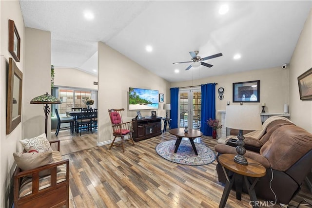 living room featuring lofted ceiling, hardwood / wood-style flooring, french doors, and ceiling fan