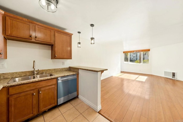 kitchen with a sink, visible vents, light countertops, dishwasher, and decorative light fixtures