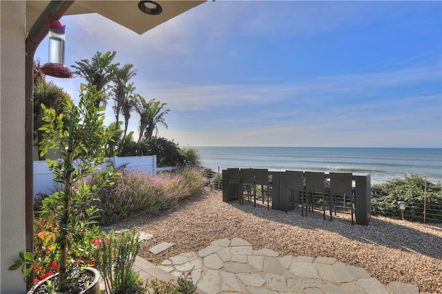 view of yard featuring a water view and a beach view