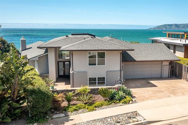 view of front of property featuring a garage and a water view