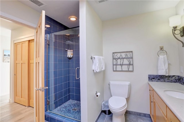 bathroom with vanity, toilet, and a shower with shower door