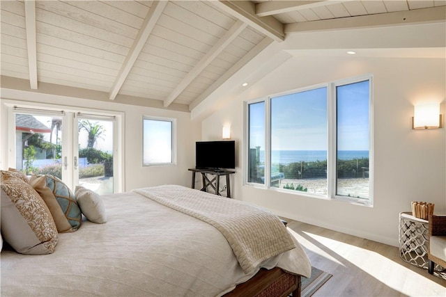 bedroom featuring lofted ceiling with beams, access to exterior, french doors, and light hardwood / wood-style flooring