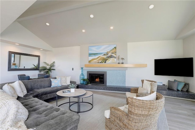 living room featuring lofted ceiling with beams and light wood-type flooring