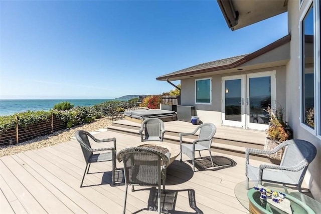 wooden deck with a water view and french doors