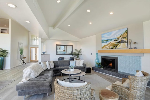 living room featuring vaulted ceiling with beams and light hardwood / wood-style floors