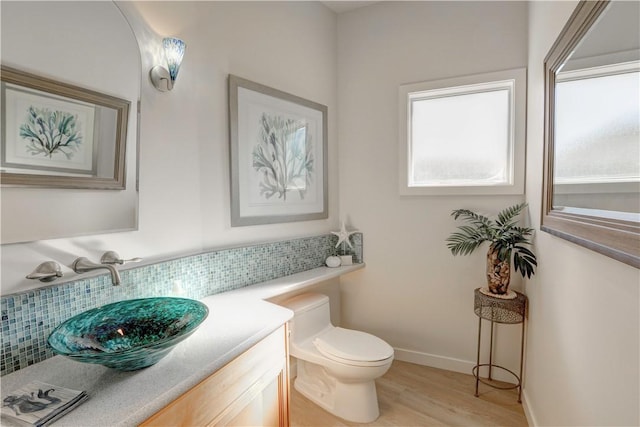 bathroom with tasteful backsplash, vanity, hardwood / wood-style flooring, and toilet