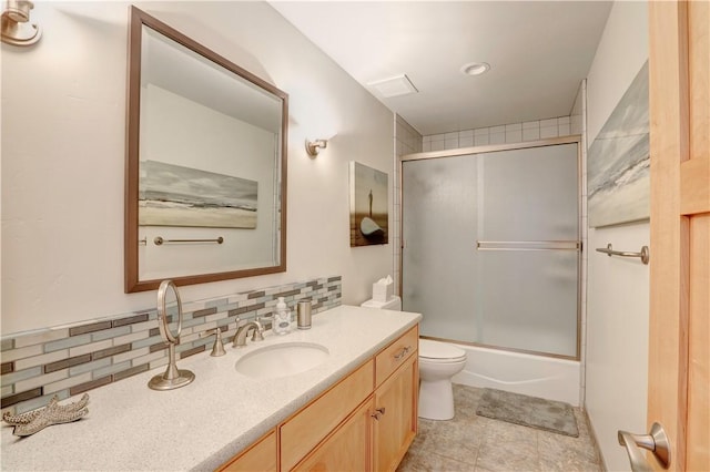 full bathroom featuring vanity, decorative backsplash, shower / bath combination with glass door, and toilet