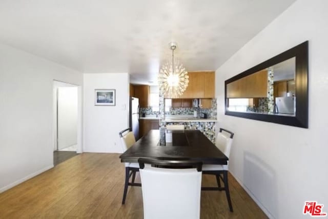 dining area with a notable chandelier and hardwood / wood-style flooring