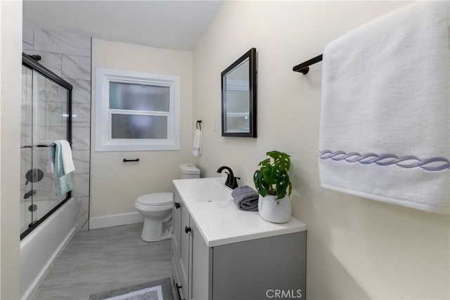 full bathroom featuring bath / shower combo with glass door, vanity, and toilet